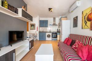 a living room with a couch and a kitchen at Apartamento Trilo 24 in Es Pujols +14 photos