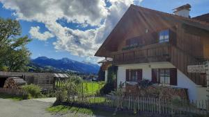 a wooden house with mountains in the background at Ferienwohnung Mair - Bergblick in Halblech