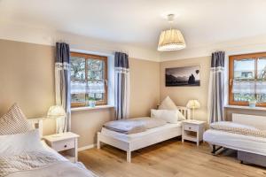 a bedroom with two beds and two windows at Ferienwohnung Mair - Bergblick in Halblech