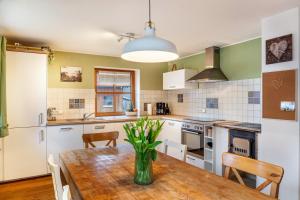 a kitchen with a wooden table with a vase on it at Ferienwohnung Mair - Bergblick in Halblech