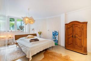 a bedroom with a bed and a wooden cabinet at Architektenhaus Baden mit Studio in Weier
