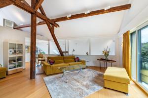 a living room with a yellow couch and a table at Architektenhaus Baden mit Studio in Weier