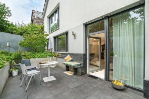a patio with a table and chairs and windows at Architektenhaus Baden mit Studio in Weier