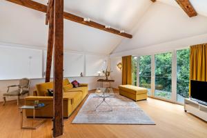 a living room with a yellow couch and a tv at Architektenhaus Baden mit Studio in Weier