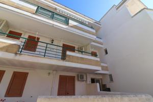 a white building with red doors and a balcony at Casa Zara a Otranto in Otranto