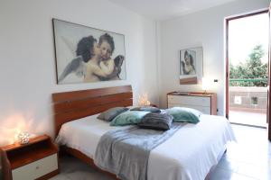 a white bedroom with a bed and a large window at Casa Zara a Otranto in Otranto