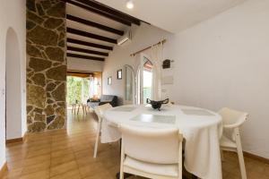 a dining room with a white table and white chairs at 5ª Avenida in S'Algar