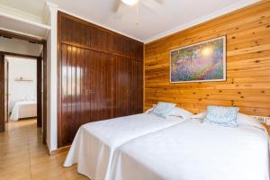 two beds in a bedroom with wooden walls at 5ª Avenida in S'Algar +17 photos