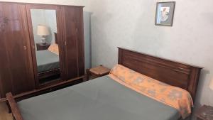 a small bedroom with a bed and a mirror at Appartement rochenoir in Saint-Jean-de-Maurienne