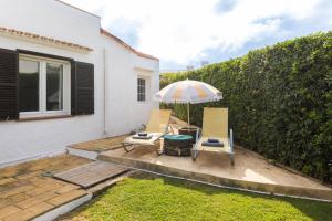 two chairs and an umbrella on a patio at 5ª Avenida in S'Algar
