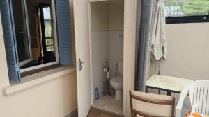 a bathroom with a toilet and a window and a table at Appartement rochenoir in Saint-Jean-de-Maurienne +5 photos