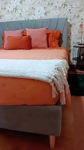 a bed with orange pillows and a blue headboard at Ká T'Espero in Penha Garcia +10 photos