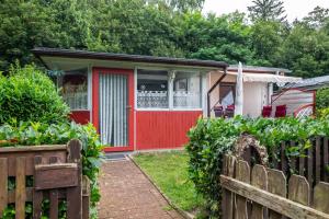 a house with a red door and a fence at Haus Seeblick in Malchow