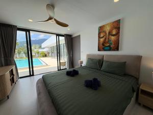 a bedroom with a large bed with two shoes on it at Coconut Villa 8 in Ban Thung +25 photos