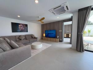 a living room with a couch and a flat screen tv at Coconut Villa 8 in Ban Thung