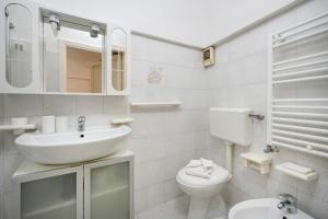a white bathroom with a sink and a toilet at Casa Pà in Ostuni +12 photos