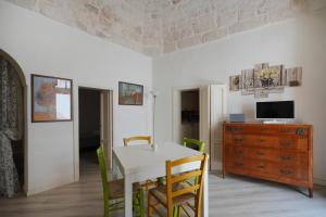 a dining room with a table and chairs and a television at Casa Pà in Ostuni