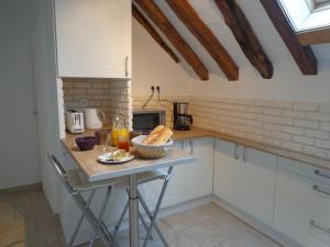 a kitchen with a table with a bowl of bread on it at Gîte De La Petite Croix Blanche in Les Riceys