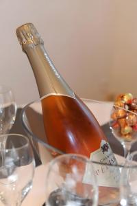 a bottle of wine sitting on a table with glasses at Gîte De La Petite Croix Blanche in Les Riceys +2 photos
