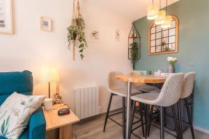 a living room with a table and a blue couch at Appartement Cap Esterel - piscine in Saint-Raphaël