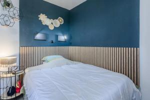 a bedroom with a bed with a blue wall at Appartement Cap Esterel - piscine in Saint-Raphaël +20 photos