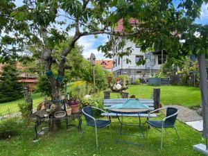 a table and chairs in a yard with a tree at Ferienwohnung im Salzgässle in Schonach