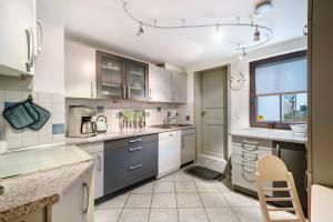 a kitchen with white cabinets and a window at Ferienwohnung im Salzgässle in Schonach