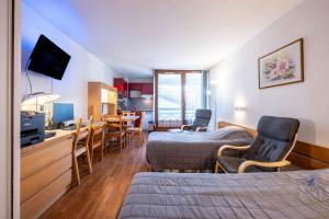 a hotel room with a bed and a dining room at Les cybeles - studio 3 personnes in Brides-les-Bains
