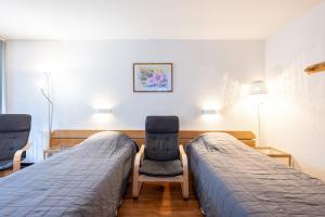 a hospital room with two beds and two chairs at Les cybeles - studio 3 personnes in Brides-les-Bains
