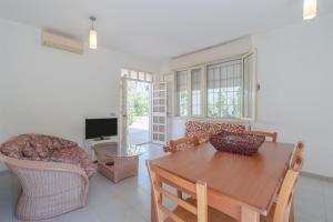 a living room with a table and chairs and a television at Villa Amore - San Lorenzo in Reitani