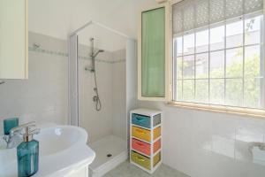 a white bathroom with a sink and a shower at Villa Amore - San Lorenzo in Reitani +16 photos
