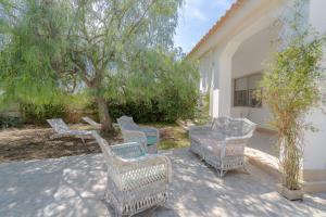 a group of wicker chairs and a table on a patio at Villa Amore - San Lorenzo in Reitani