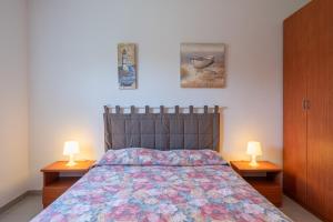 a bedroom with a bed with two nightstands and two lamps at Villa Amore - San Lorenzo in Reitani