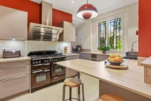 a kitchen with a stove and a table with a bowl of fruit at Villa Chantegrive in Roquebrune-sur-Argens