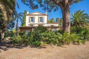 a house on the beach with palm trees at Villa Chantegrive in Roquebrune-sur-Argens