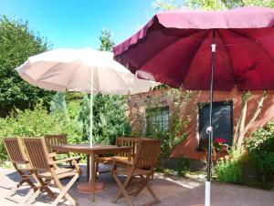 a table and chairs under a red umbrella at Feriendomizil Fliedereck in Malchin