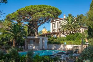 a villa with a swimming pool and a tree at Villa Chantegrive in Roquebrune-sur-Argens
