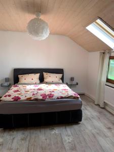 a bedroom with a bed with a floral comforter at Lieblingsplatz in Weiler-Simmerberg