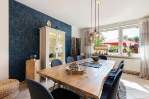 a dining room with a wooden table and chairs at Ferienhaus Ankerglück in Lensahn