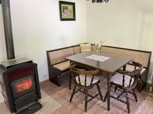 a dining room with a wood stove and a table at Ferienhaus Maierhofer in Fischbach