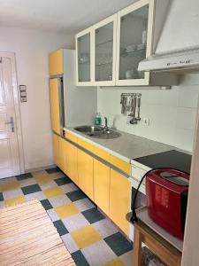 a kitchen with yellow and white cabinets and a sink at Ferienhaus Maierhofer in Fischbach +4 photos