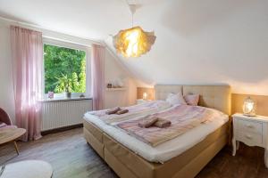 a bedroom with a large bed and a window at Ferienhaus Ankerglück in Lensahn