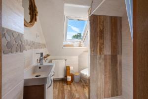 a bathroom with a sink and a toilet at Ferienhaus Ankerglück in Lensahn +26 photos