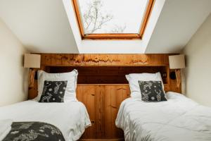two beds in a room with a window at L'éclos des vignes - Appartements haut de gamme avec Spa in Bergheim +100 photos