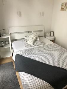 a bedroom with a bed with white sheets and pillows at Tiny Haus Liederbach in Alsfeld
