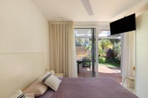 a bedroom with a bed and a view of a patio at Casa Nirvana - Penthouse in Sitges
