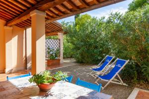a group of blue chairs and a table on a patio at Trilo Dalia in Marina di Grosseto