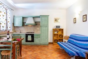 a kitchen with green cabinets and a table and a chair at Trilo Dalia in Marina di Grosseto