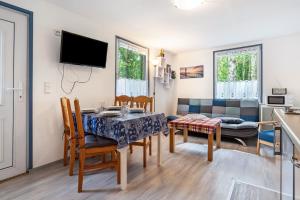 a dining room and living room with a table and chairs at Bungalow Bark Sedov, Bgl 3 in Dranske