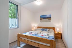 a bedroom with a bed and a window at Bungalow Bark Sedov, Bgl 3 in Dranske